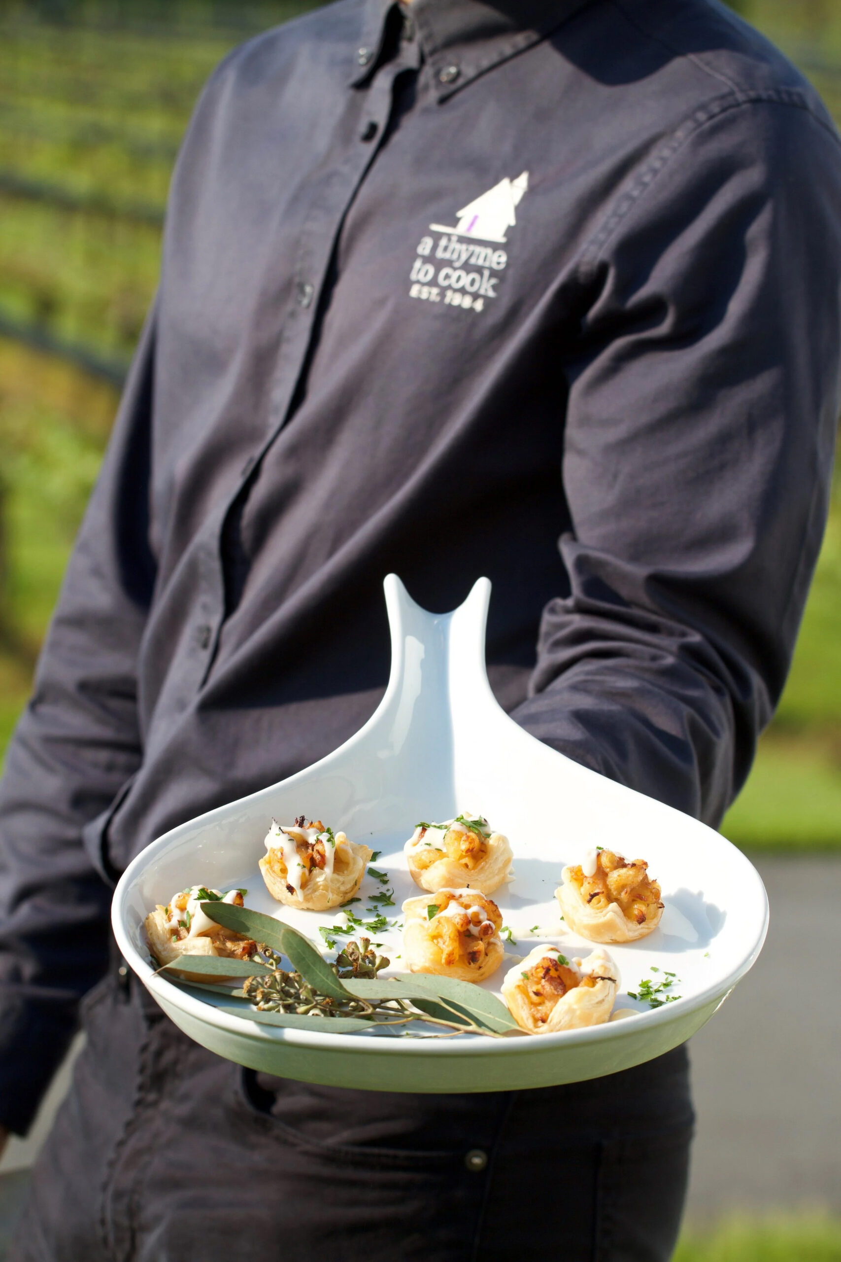 person holding a tray of scallop appetizers